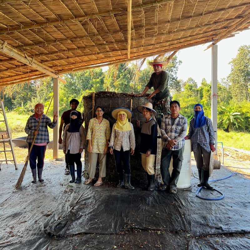 Our farm team together under the thatched roof