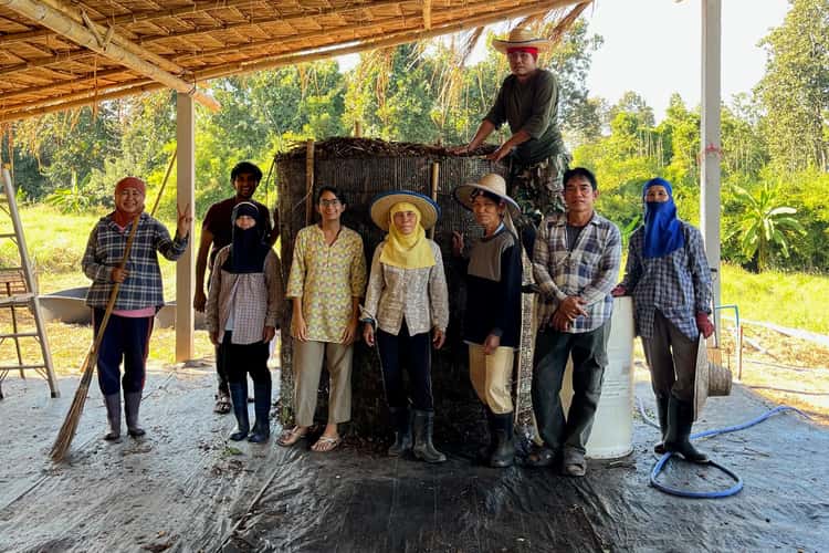 Our farm team together under the thatched roof